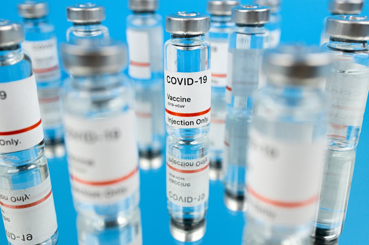 Close-up of COVID-19 vaccine vials with syringe in a studio setting.